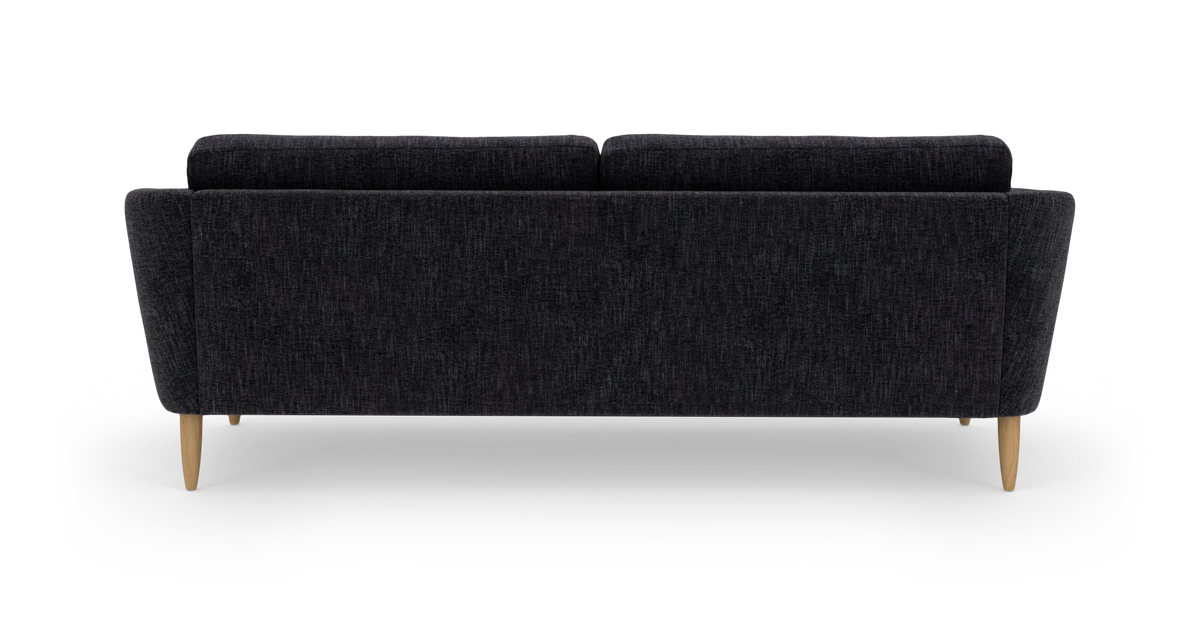Mørkegrå sofa set bagfra med lyse træben på hvid baggrund.