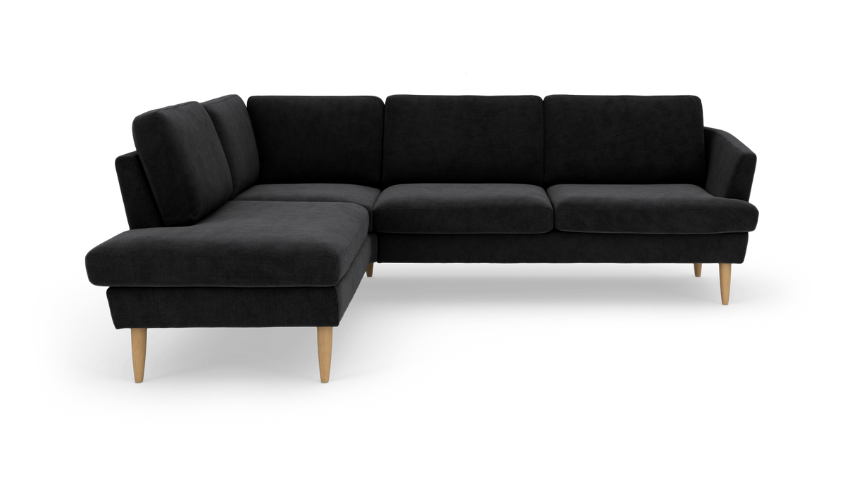 Sort L‑sofa med chaiselong til venstre og lyse træben, enkel og moderne.