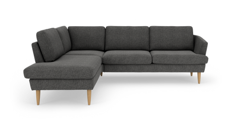 Mørkegrå L‑formet hjørnesofa med chaiselong til venstre og lyse træben, frilagt på hvid baggrund.