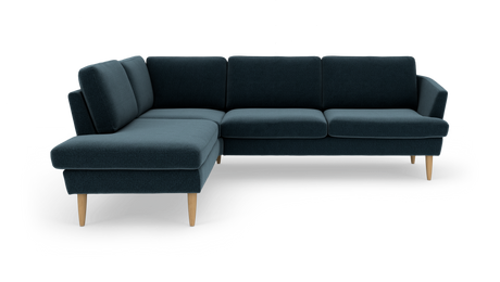 Mørk teal L‑sofa med venstrevendt chaiselong og lyse, tilspidsede træben.