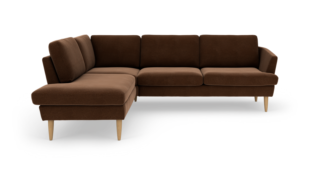 Brun L-formet hjørnesofa med chaiselong til venstre og lyse træben, frilagt på hvid baggrund.