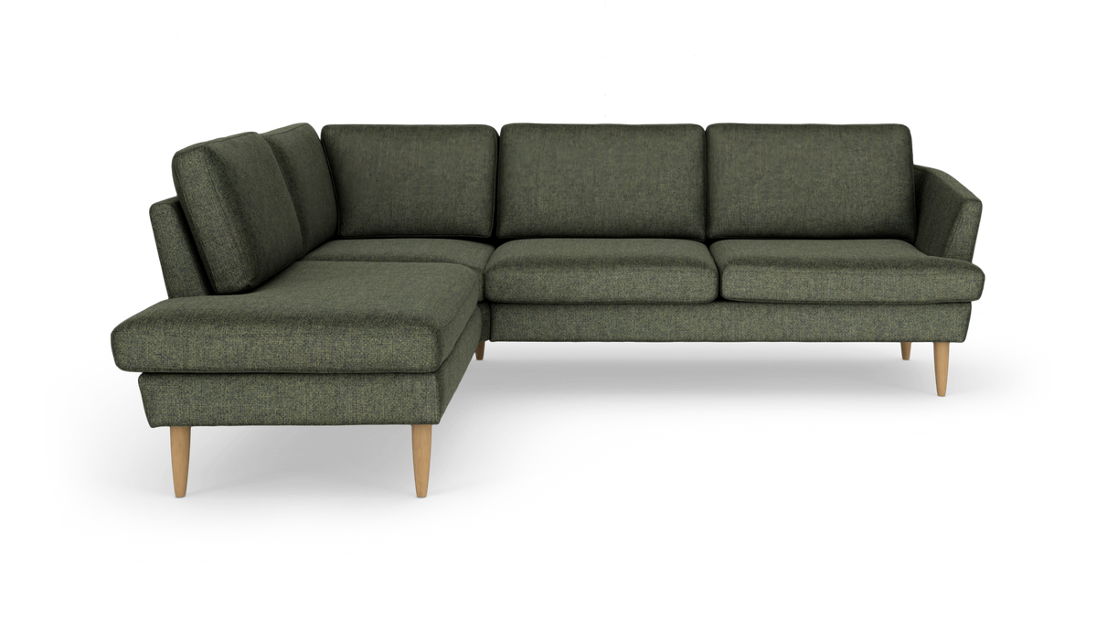 Grøn hjørnesofa med chaiselong til venstre, stofbetræk og koniske træben, frilagt på hvid baggrund.