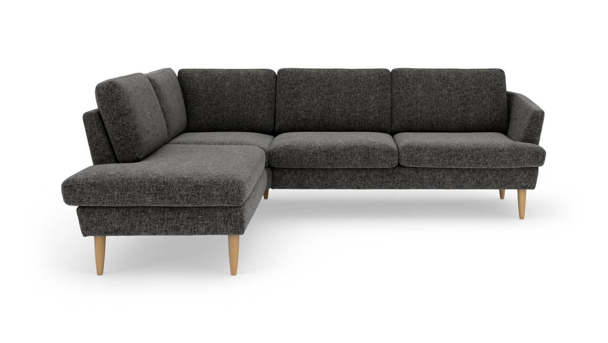 Mørkegrå L-sofa med chaiselong og lyse træben, frilagt på hvid baggrund.
