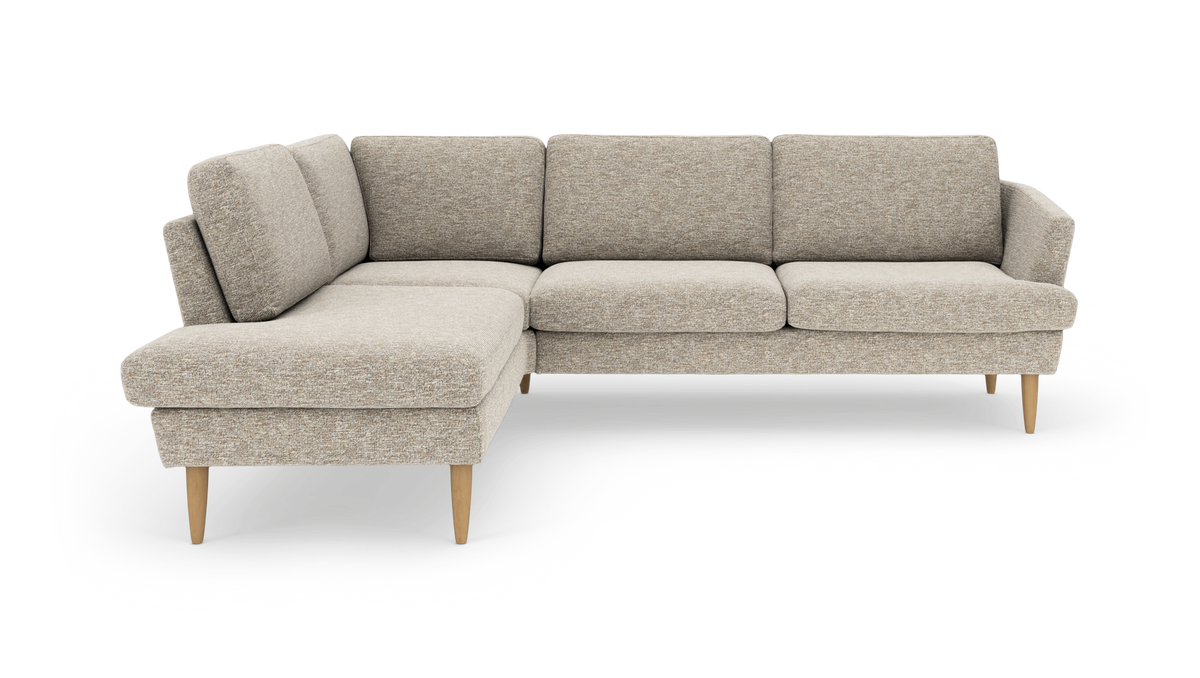 Beige L-formet hjørnesofa i stof med venstrevendt chaiselong og koniske træben, frilagt mod hvid baggrund i studielys.