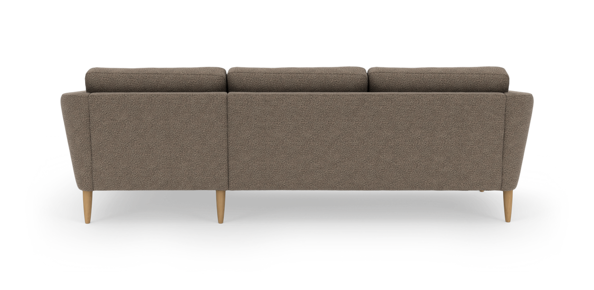 Brun stofsofa set bagfra med lyse træben i studiemiljø.
