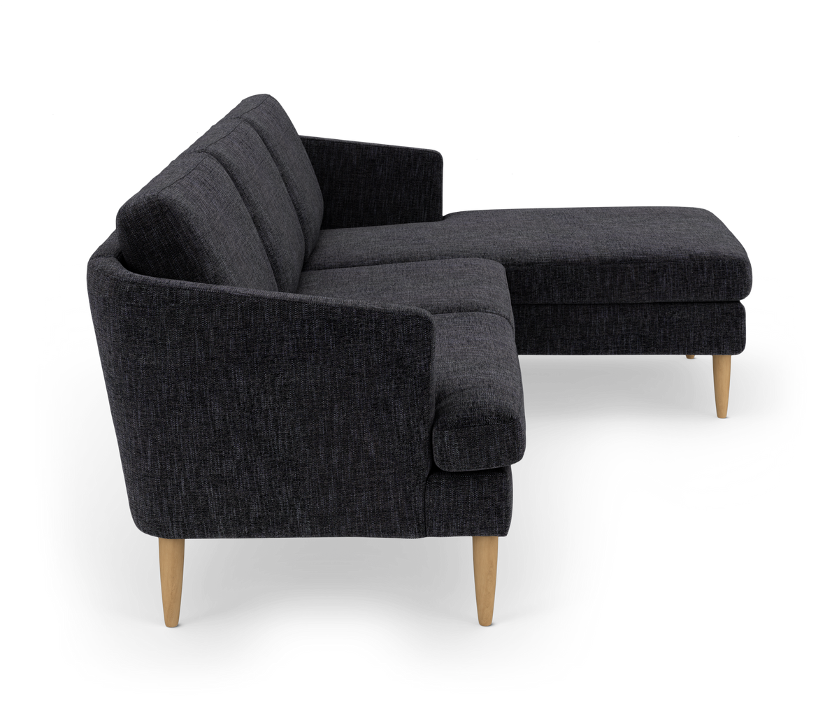 Mørkegrå hjørnesofa med chaiselong og lyse træben, frilagt mod hvid baggrund.