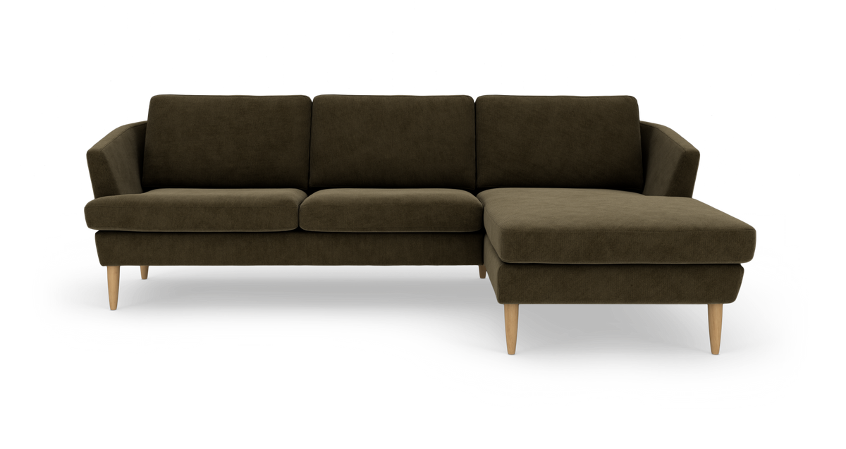 Mørk olivengrøn hjørnesofa med chaiselong til højre og lyse træben, frilagt på hvid baggrund.
