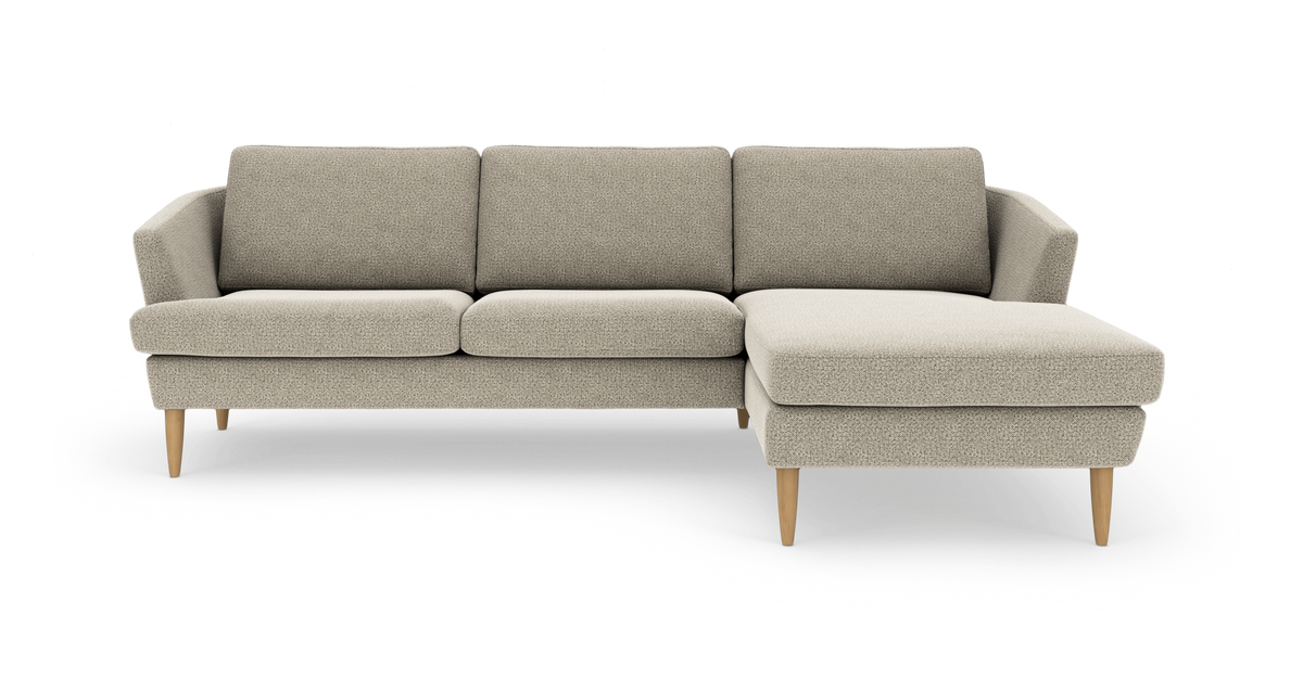 Beige hjørnesofa med chaiselong til højre og træben på hvid studiobaggrund.