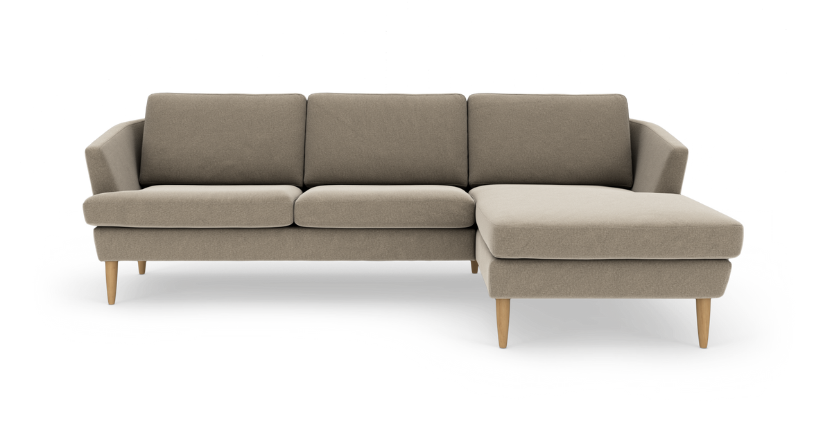 Beige hjørnesofa med chaiselong til højre og træben, frilagt på hvid baggrund.