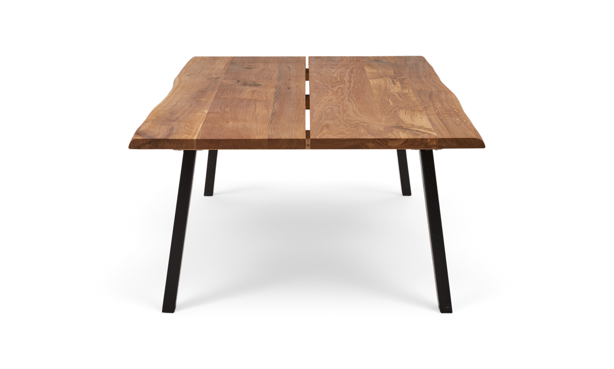 Rektangulært spisebord i massiv eg med live edge og to-planke bordplade på sorte metalben, frontvisning.