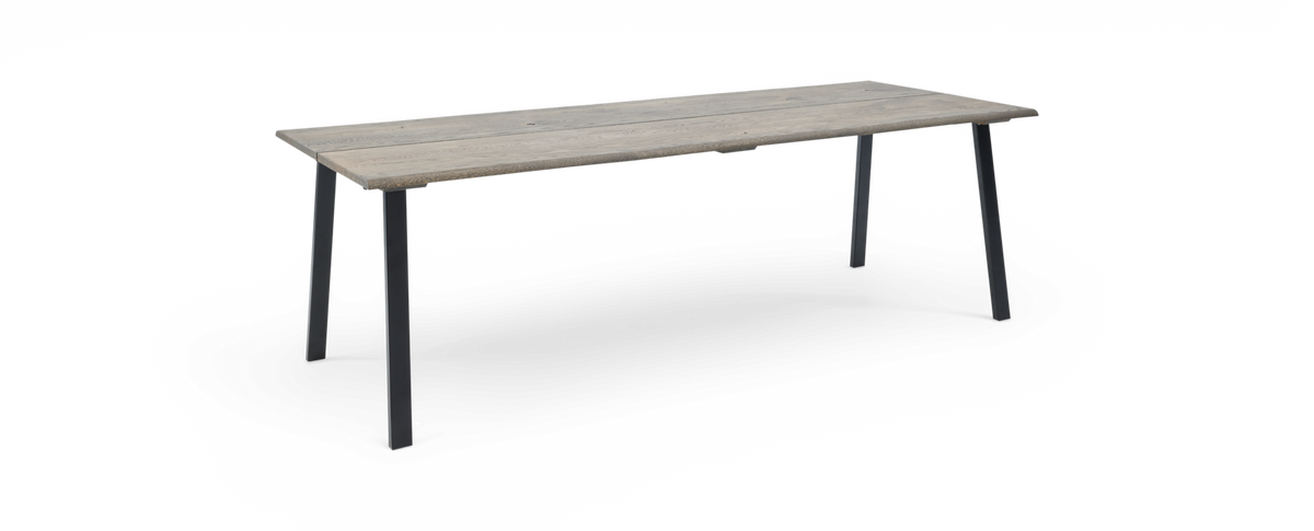 Rektangulært spisebord i rustikt lysegråt træ med slanke sorte metalben, frilagt produktbillede.