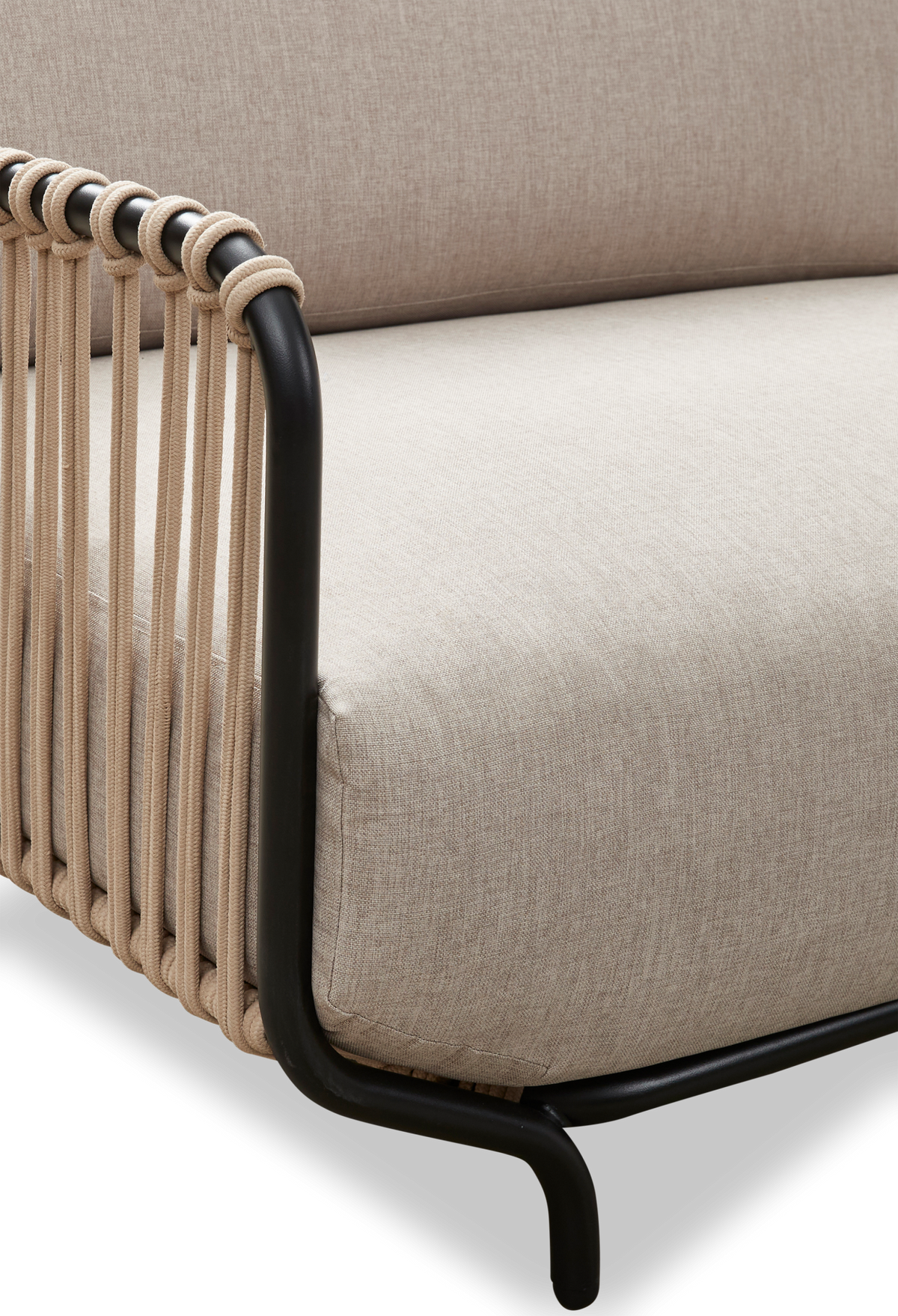 Nærbillede af beige sofa med sort metalramme og flettet rebdetalje i armlænet.