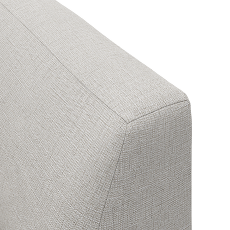 Nærbillede af beige polsterstof og syning på et sofa-hjørne, frilagt på hvid baggrund.