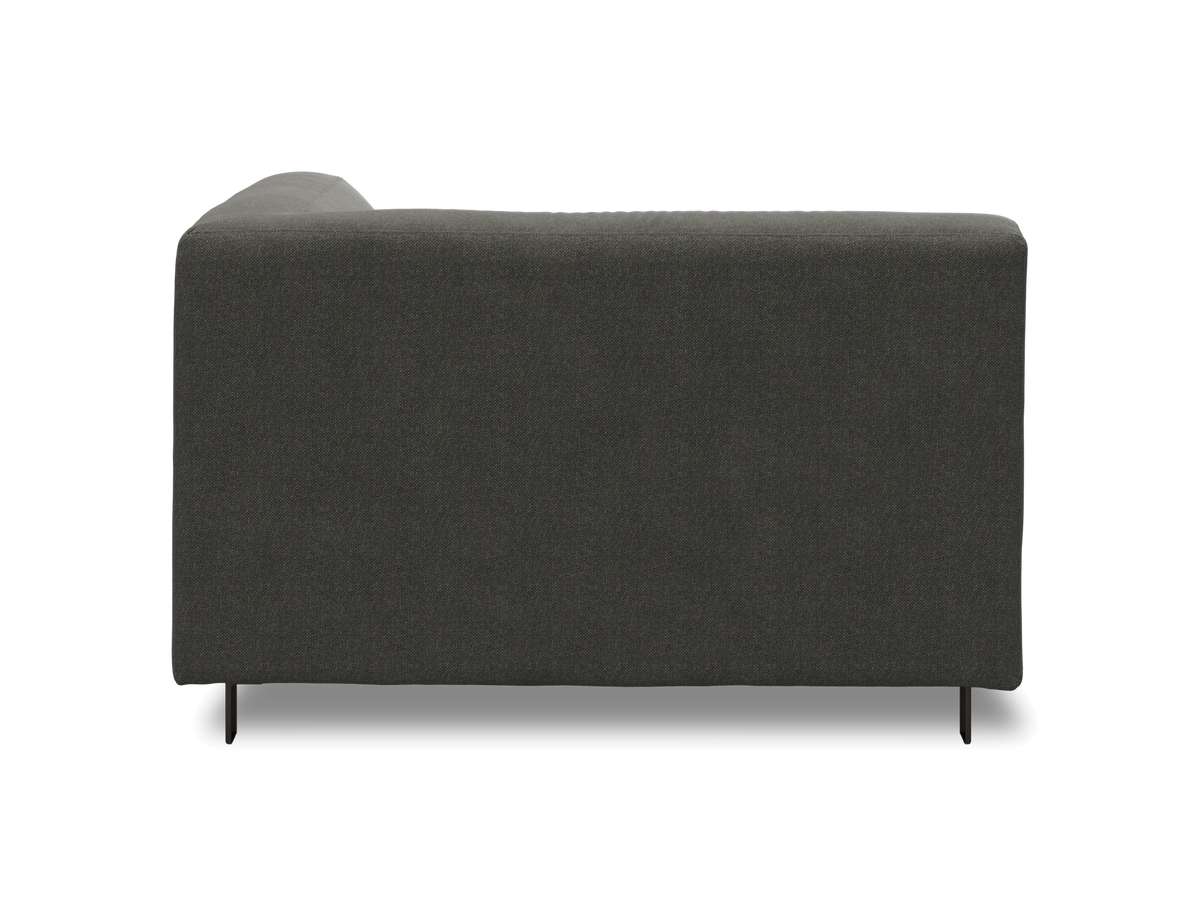 Mørkegrå sofa set fra siden på hvid baggrund.