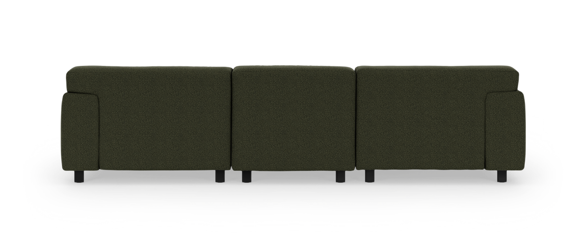 Mørkegrøn modulsofa set bagfra på hvid studiebaggrund.