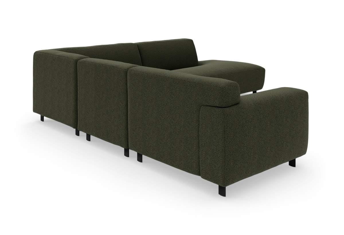 Modulær hjørnesofa i mørkegrønt stof med afrundede armlæn og slanke sorte ben, frilagt produktbillede.