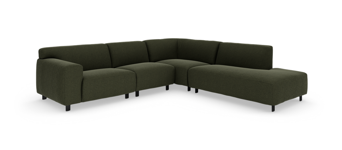Mørkegrøn modulsofa i L‑form med chaiselong, frilagt på hvid baggrund.