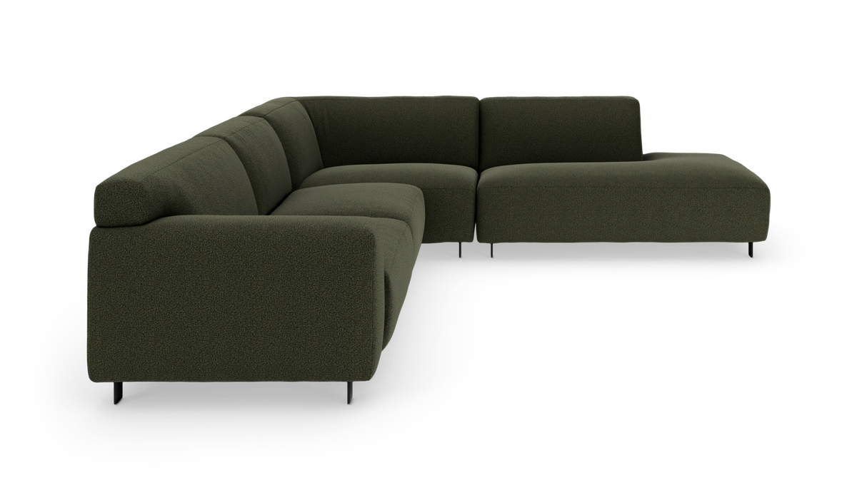 Modulær hjørnesofa i mørkegrønt stof med slanke sorte ben, vist fritlagt på hvid baggrund.