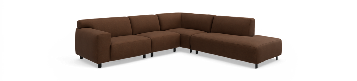 Brun L‑formet modulsofa med lav ryg og sorte ben mod sort baggrund.