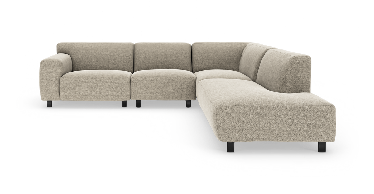 Modulær L-formet sofa i beige stof med sorte ben, vist i vinkel.