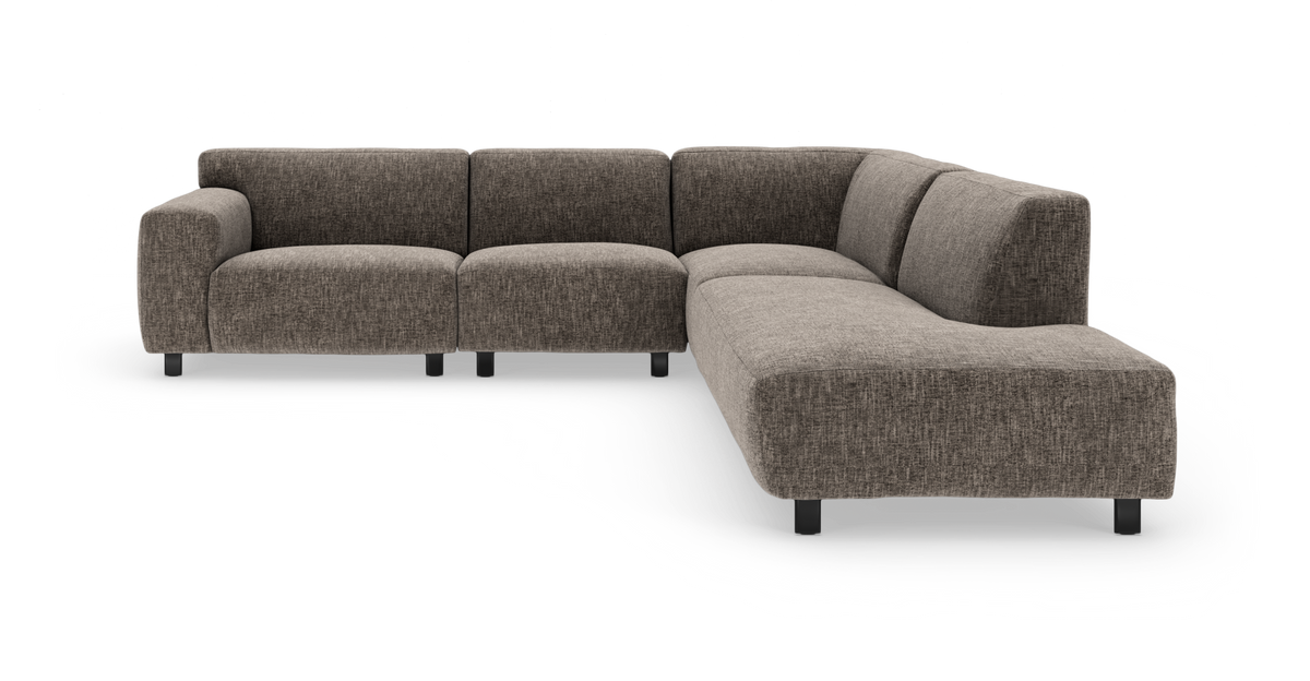 Modulsofa i brungråt stof med højre chaiselong, bløde afrundede former og sorte ben.