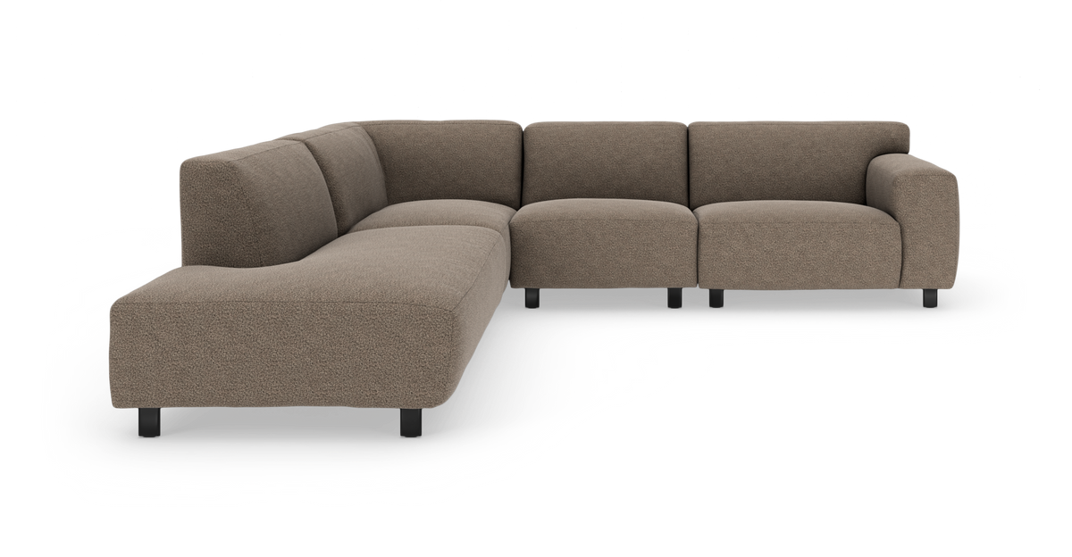 Brun L-formet modulsofa med afrundede sæder og lave sorte ben, fotograferet i studie fra skråt forfra.