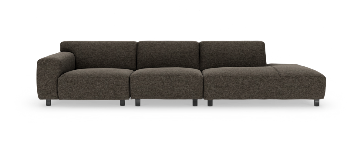 Modulsofa i mørkebrun tekstil med venstre armlæn og chaiselong til højre, fritlagt mod hvid baggrund, frontvisning.