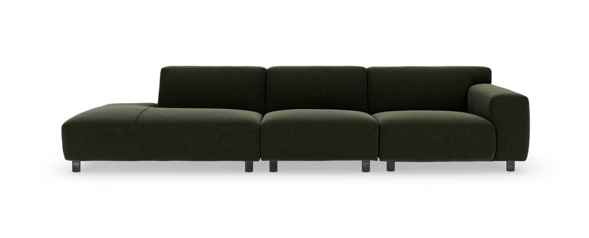 Mørkegrøn modulsofa med chaiselong til venstre og bredt højre armlæn, frilagt på hvid baggrund.