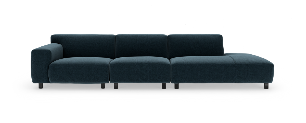 Mørkeblå modulsofa med venstre armlæn og højre chaiselong, frilagt mod hvid baggrund i frontvisning.