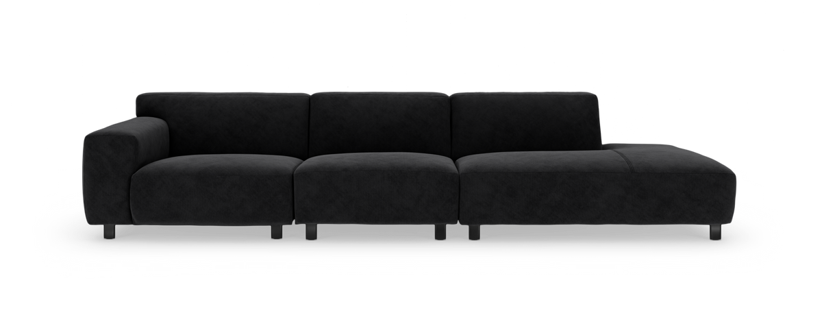 Sort modulsofa med chaiselong til højre, fotograferet forfra i studie på hvid baggrund.