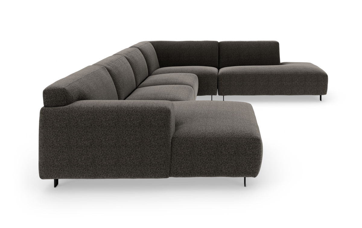 Modulær L-formet hjørnesofa i mørkegråt stof med lav profil og slanke ben, studiebillede.