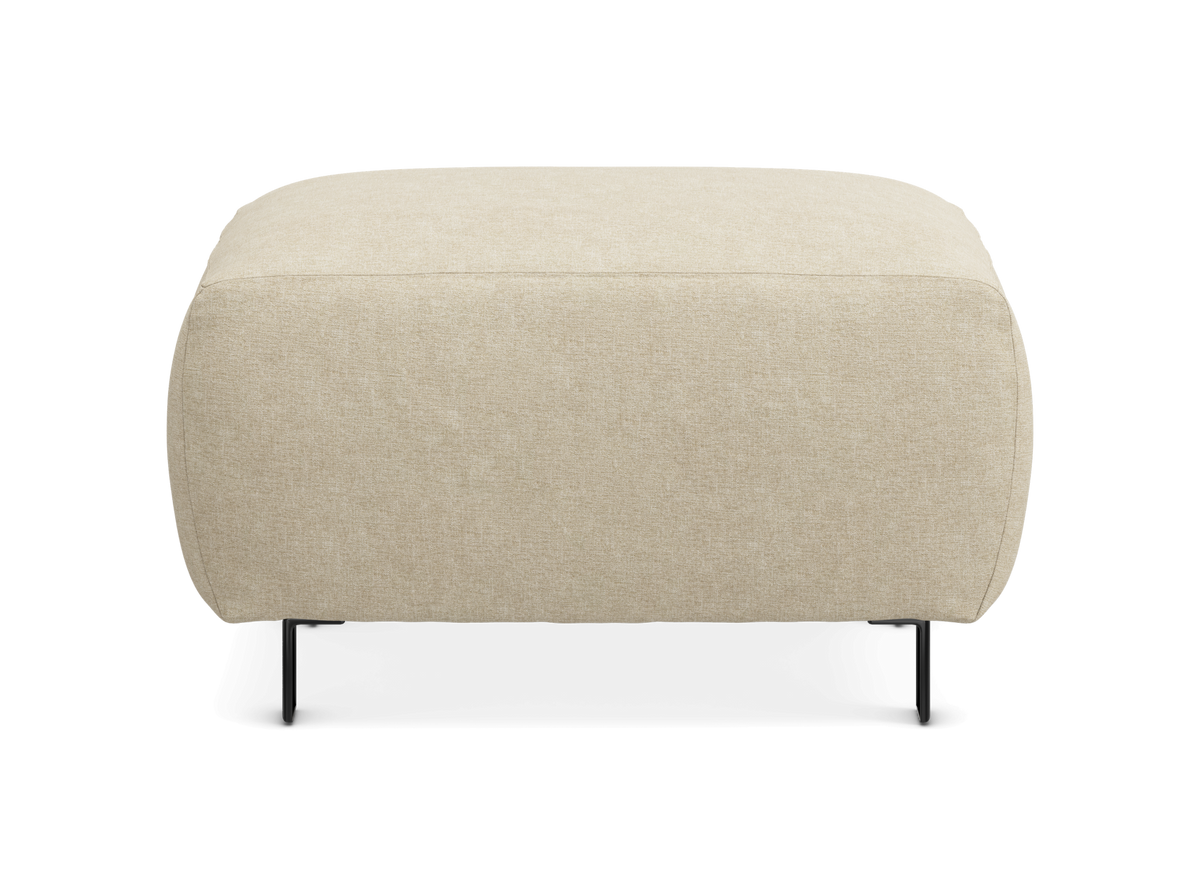 Beige puf/ottoman med afrundede kanter og slanke sorte ben, fotograferet forfra.