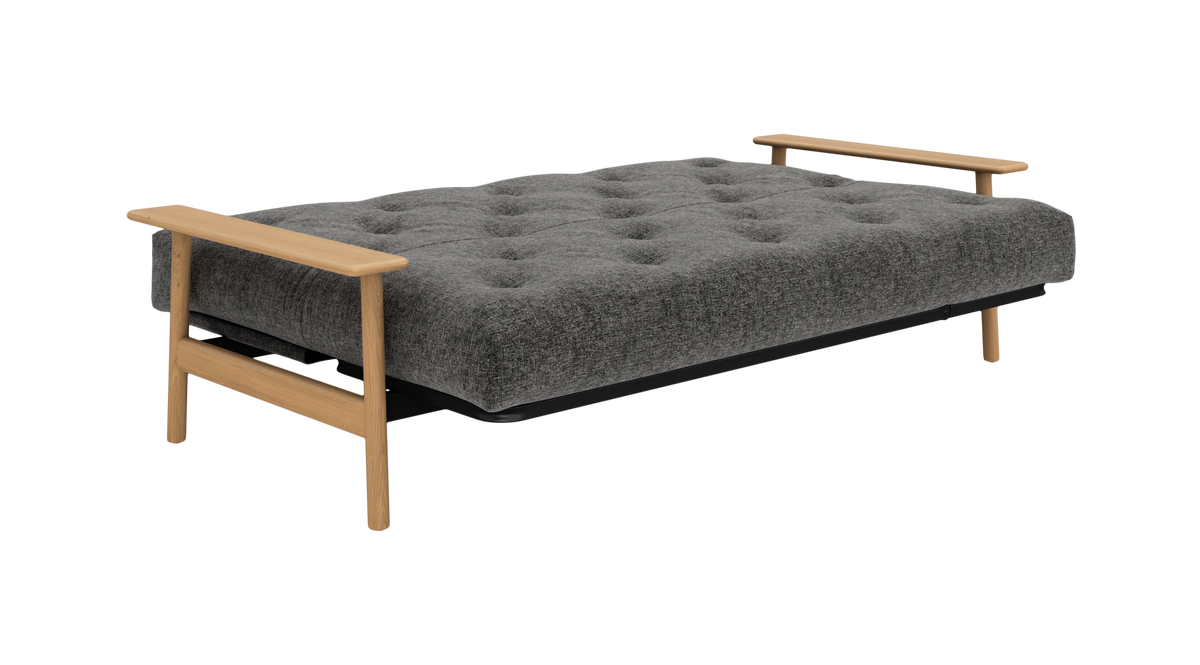 Grå, knapstukket sovesofa med træarmlæn, vist i udslået liggestilling.