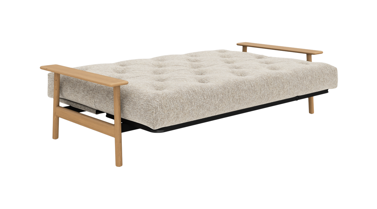 Beige udslået sovesofa med knapquiltet madras og armlæn i lyst egetræ, frilagt produktfoto.