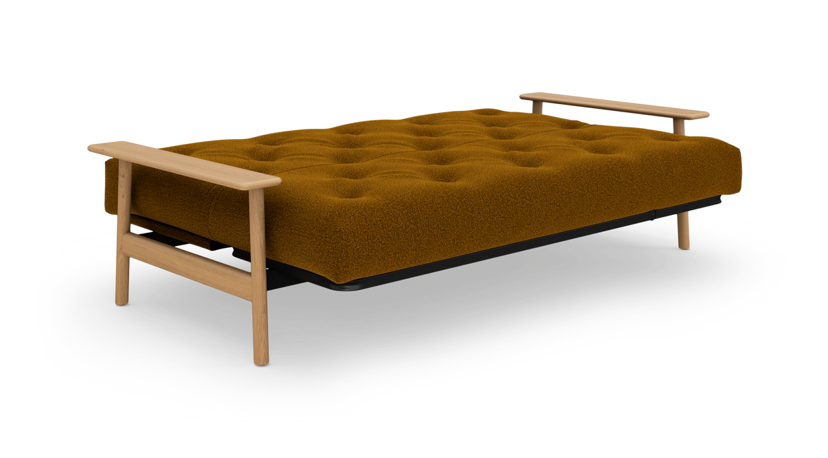 Sovesofa i udslået position med sennepsgul bouclépolstring og lyse armlæn i træ, frilagt på hvid baggrund.