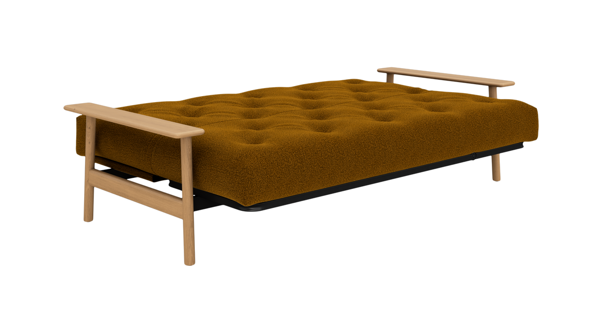 Sennepsgul tuftet futon sovesofa med lyse træarmlæn, frilagt produktfoto.