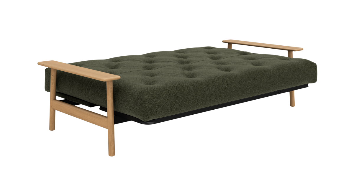 Grøn sovesofa i bouclé med lyse træarmlæn, set skråt forfra på hvid baggrund.
