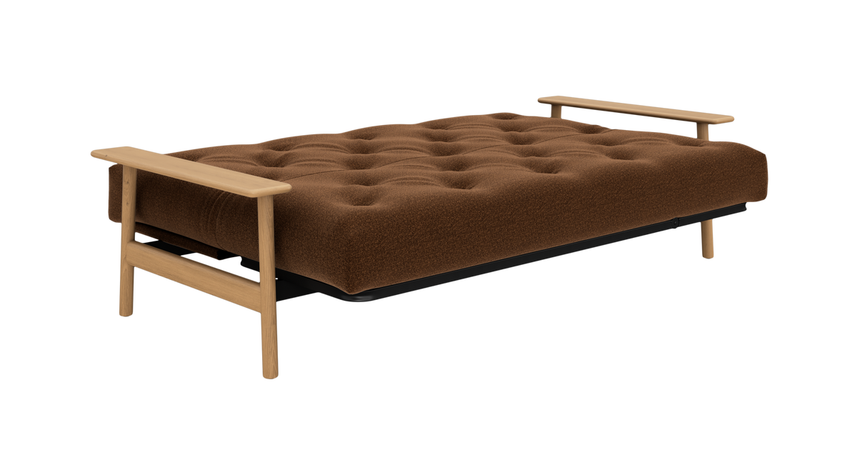 Brun, tufted sovesofa med lyse træarmlæn, frilagt i studie.