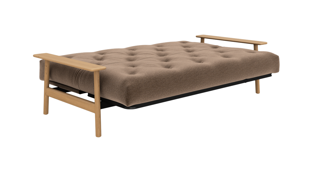 Brun, knap-quiltet sovesofa i udfoldet position med lyse træarmlæn og ben, fotograferet i studie.