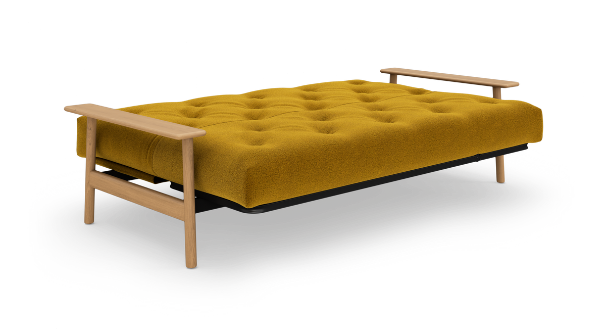 Sennepsgul tufted sovesofa med træarmlæn, fritlagt på hvid baggrund.