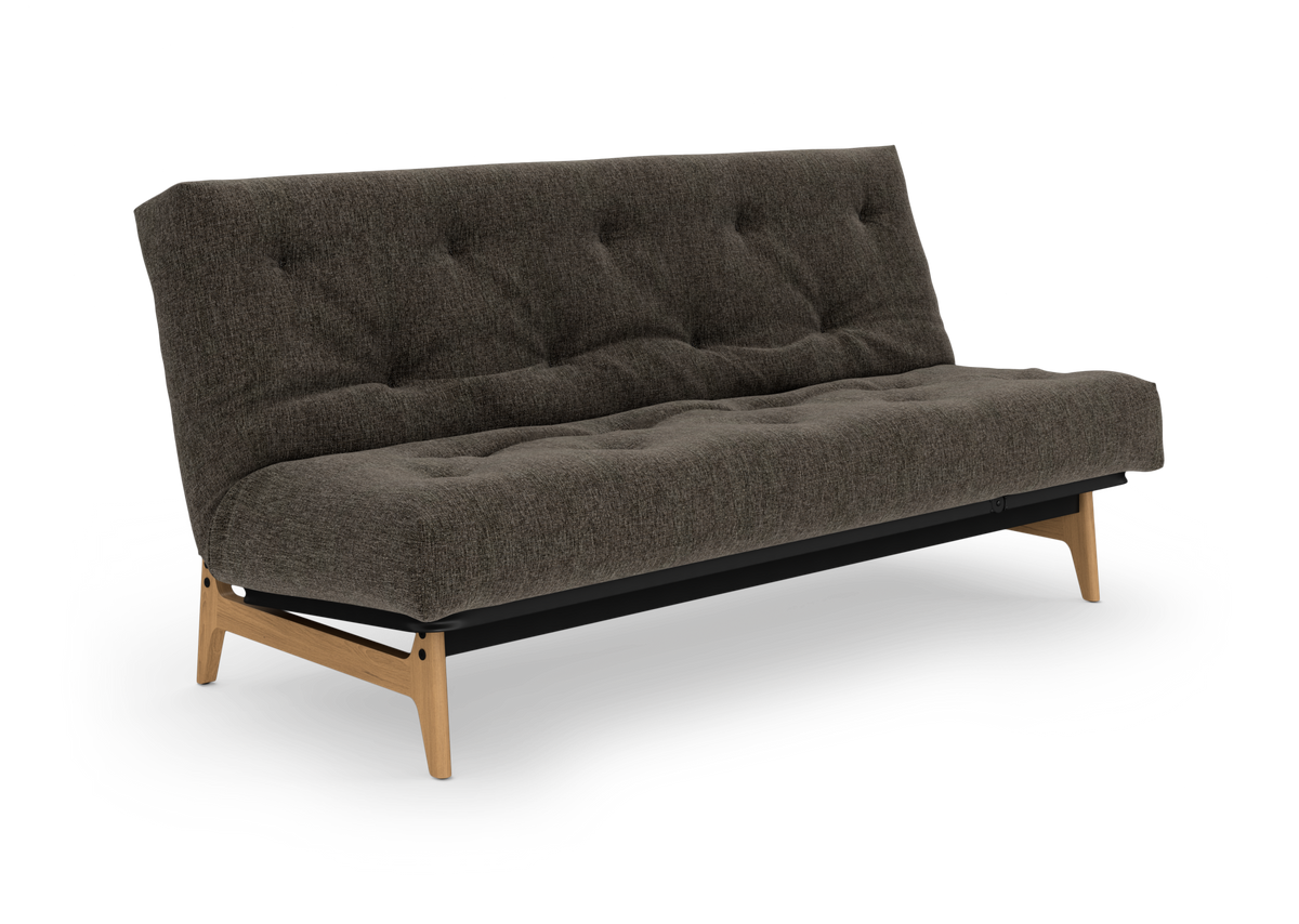 Brungrå sovesofa med tuftet sæde og ryg, træben i egetone.
