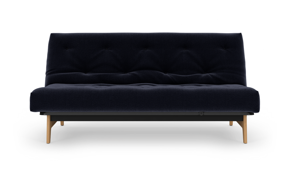 Mørkeblå tufted sofa med lyse træben, frilagt på hvid baggrund, set lige forfra.