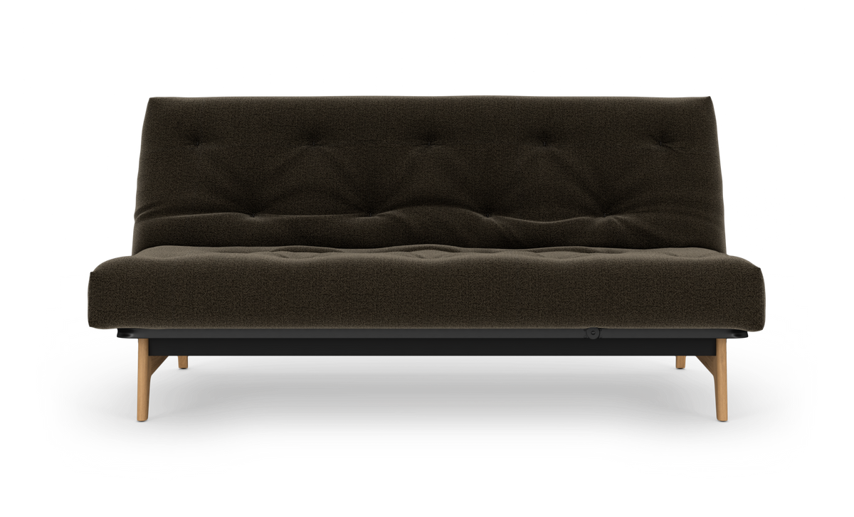 Frilagt produktbillede af en mørkebrun, knapquiltet sofa med træben set forfra.
