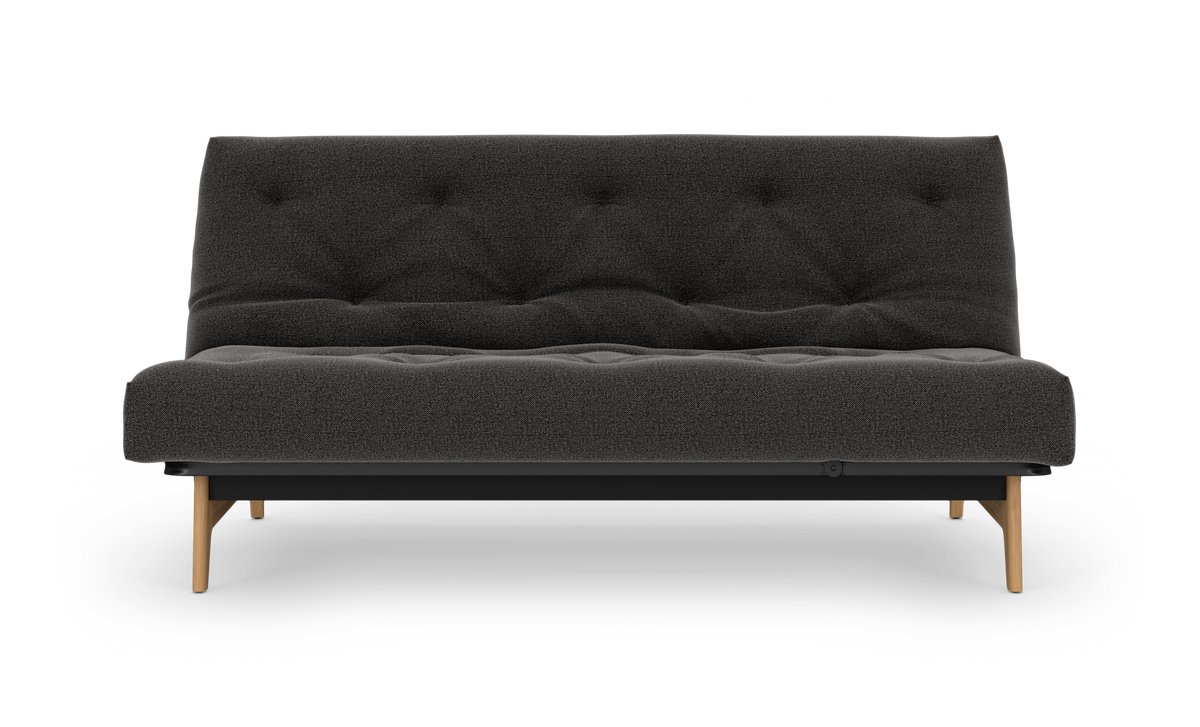 Mørkegrå, tuftet tosædet sofa med træben, set forfra på hvid baggrund.