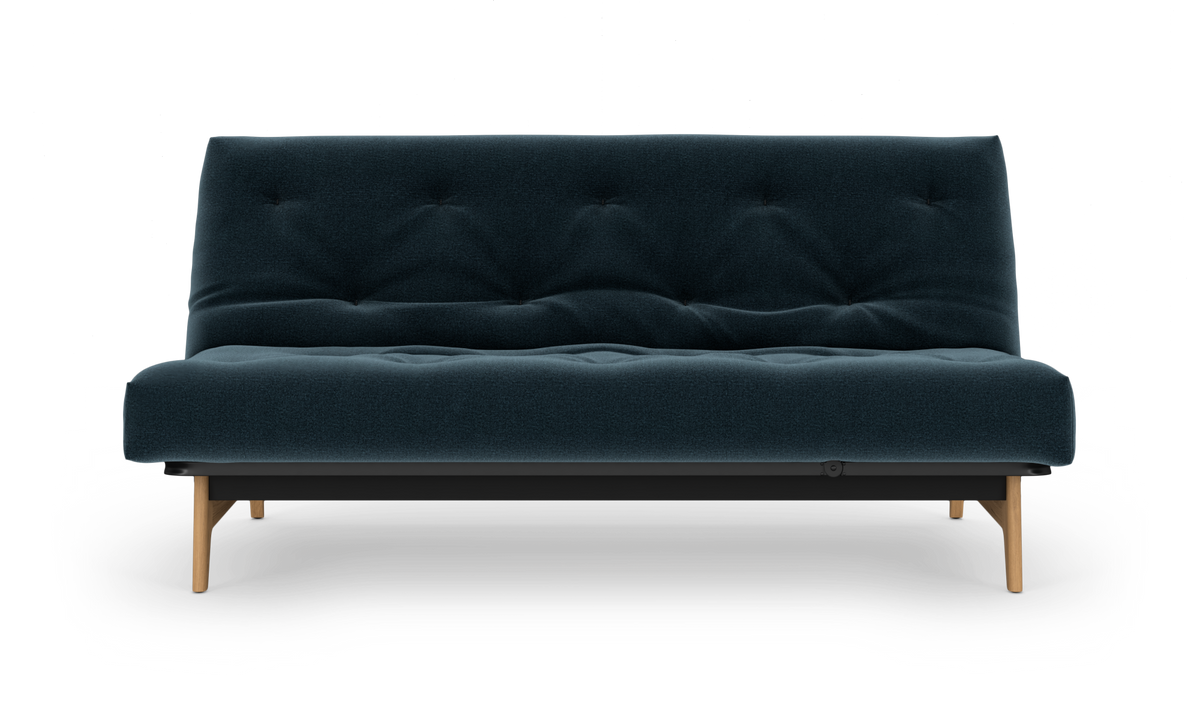 Mørkeblå, tuftet sofa med træben, frilagt på hvid baggrund i frontvisning.