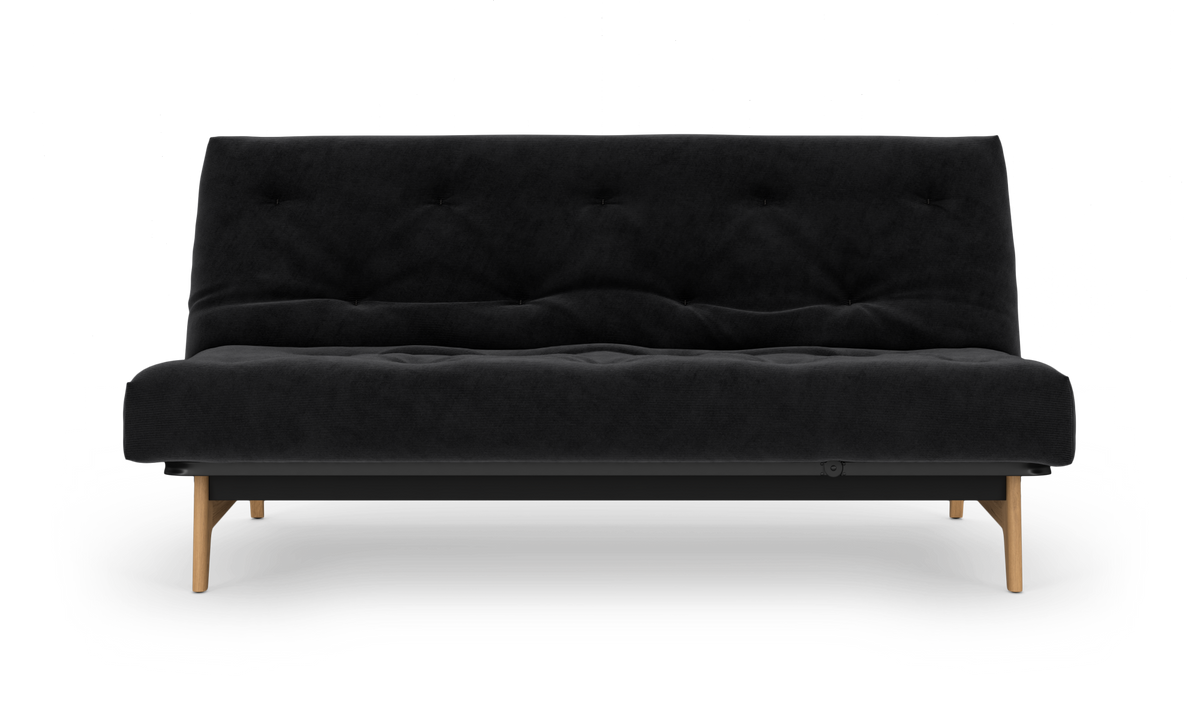 Sort, knapstukket sovesofa med træben set lige forfra, frilagt på hvid baggrund.