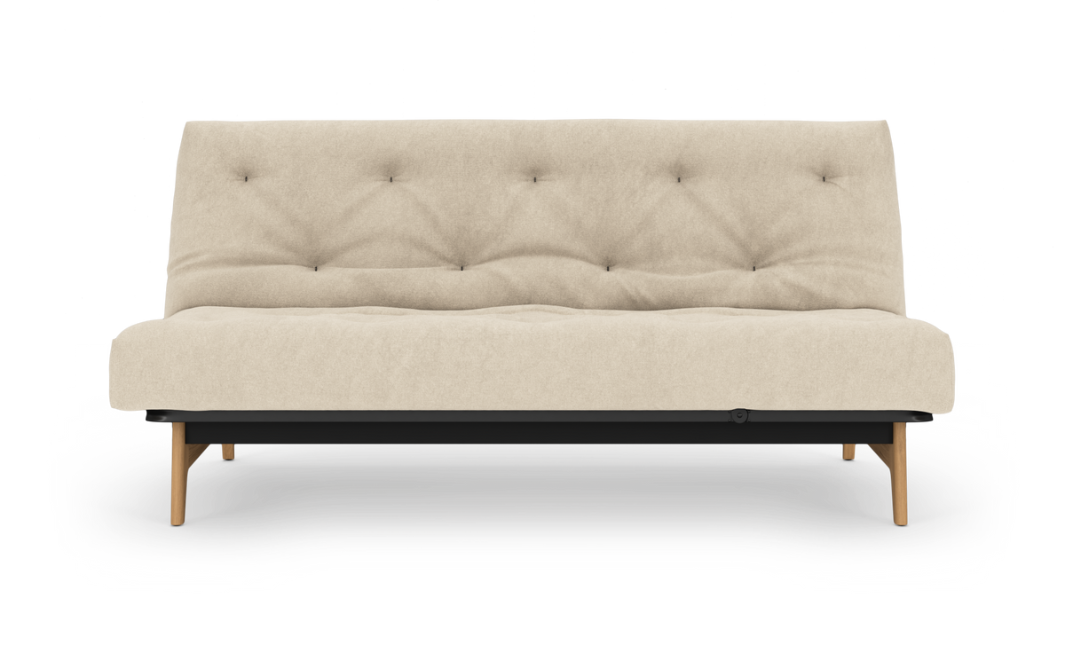 Beige, knappet sovesofa på hvid baggrund med træben og sort base, set forfra.