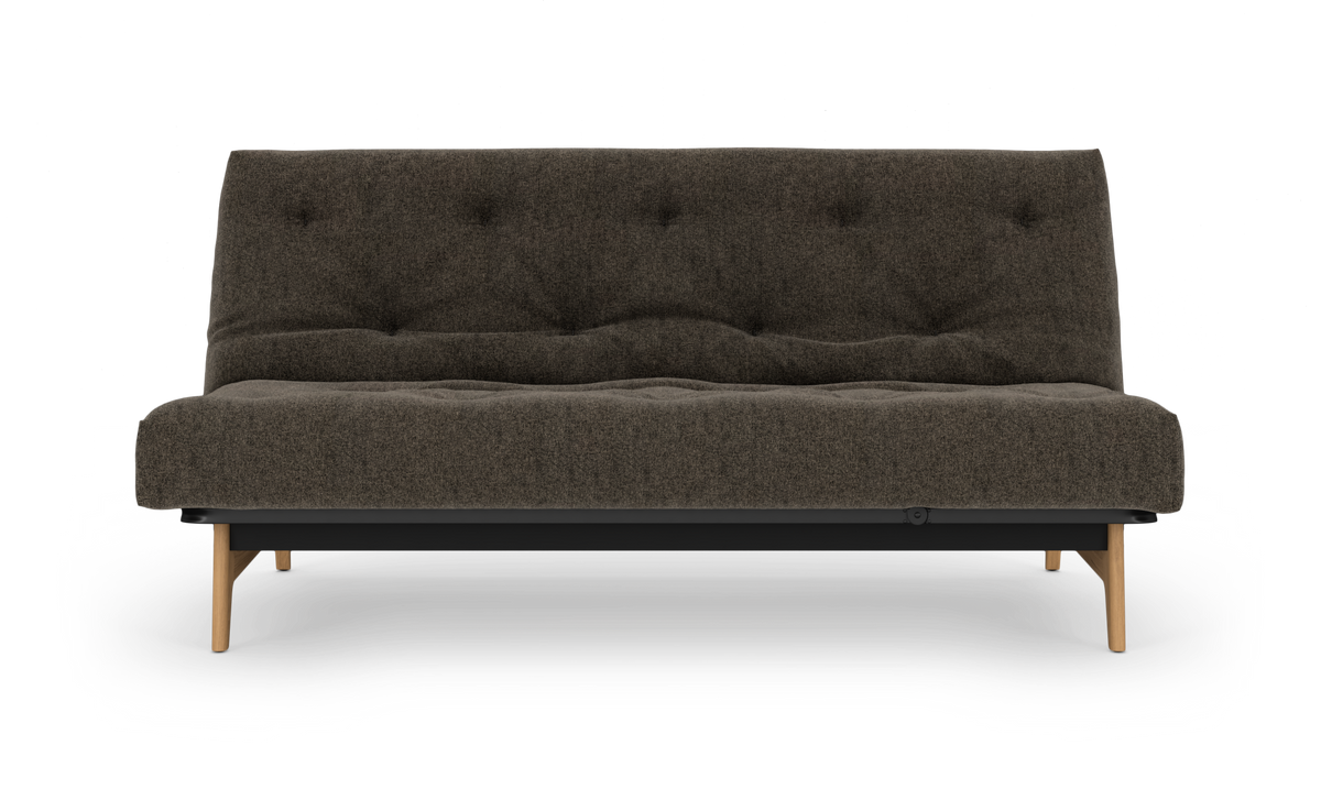 Mørkebrun sofa med træben, set forfra på hvid baggrund.