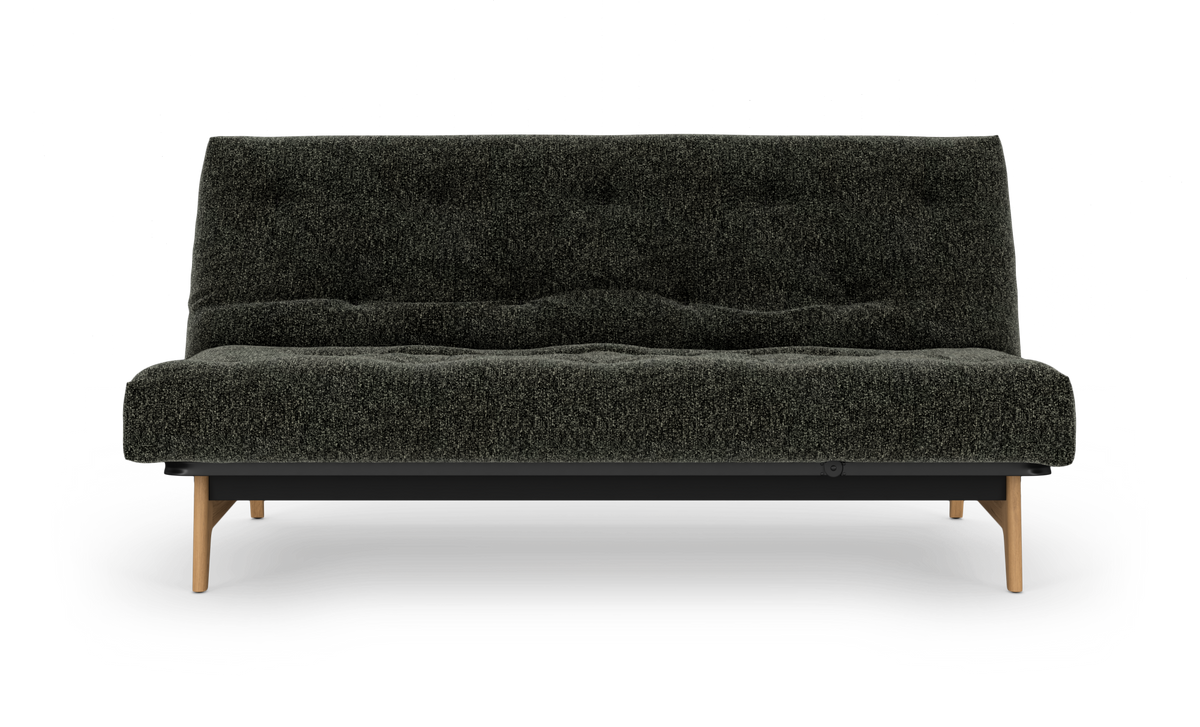 Mørkegrå sofa med tekstureret polstring og lyse træben, fotograferet lige forfra mod hvid baggrund.