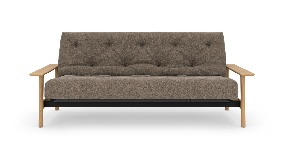 Front af en moderne sofa med beige, tekstureret polstring og tuftet ryg, træarmlæn og ben; frilagt på hvid baggrund.